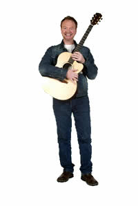 Picture of Patrick standing with his guitar